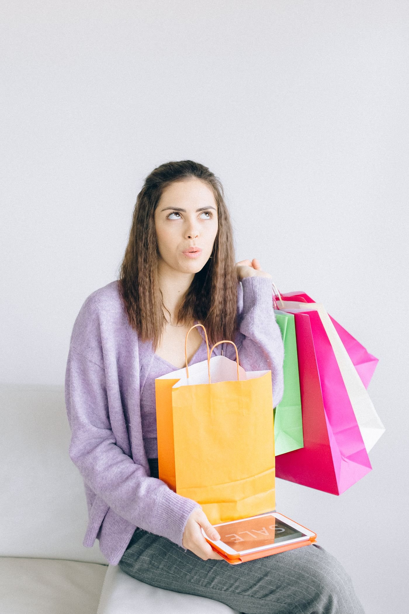 Woman holding shopping bags and a tablet